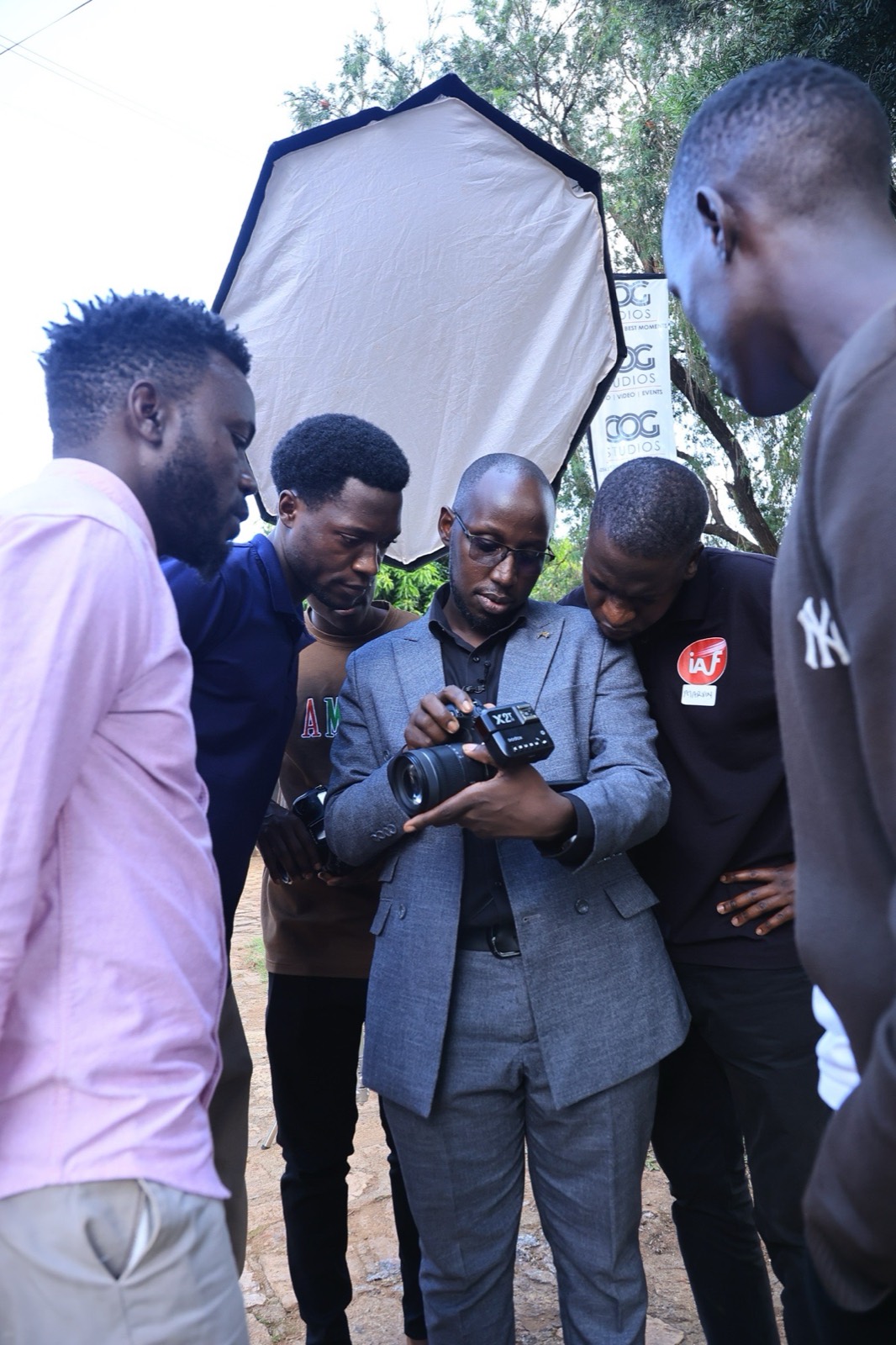 COG Studios team reviewing a professional camera during an outdoor production