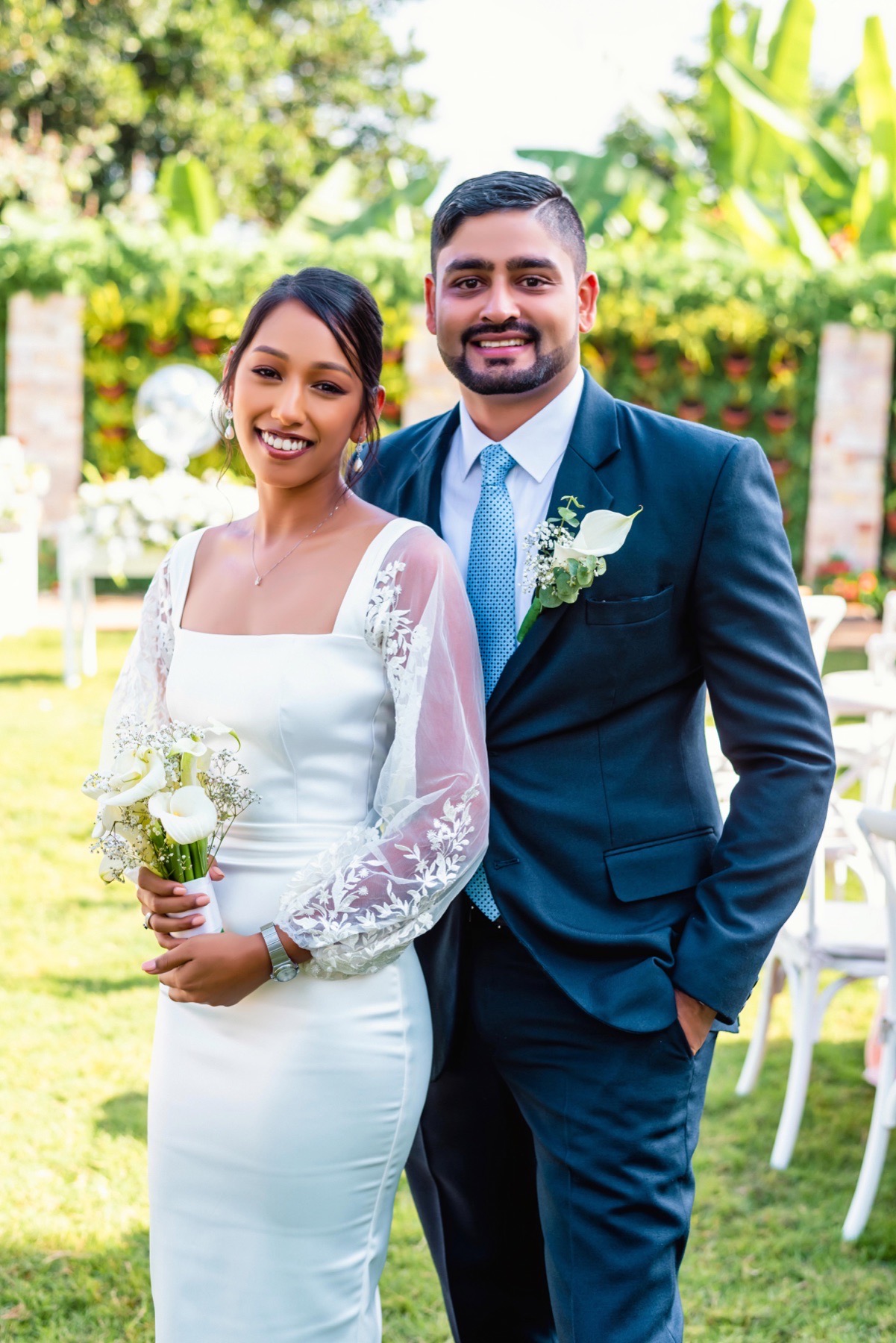 Newly married couple posing together in a garden